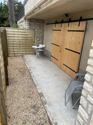 a patio with a table and a wooden door at Joli logement au pied des Alpilles in Eyguières