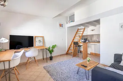 a living room with a couch and a dining room at Studio cosy place de la mairie in Aix-en-Provence