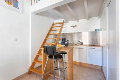 a kitchen with a ladder and a table in a room at Studio cosy place de la mairie in Aix-en-Provence
