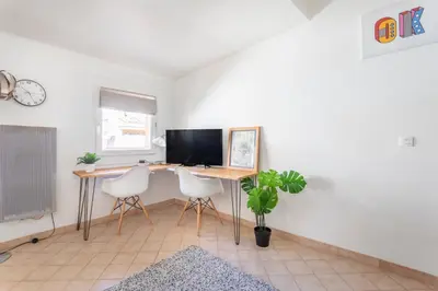 a room with a desk with a computer and two chairs at Studio cosy place de la mairie in Aix-en-Provence