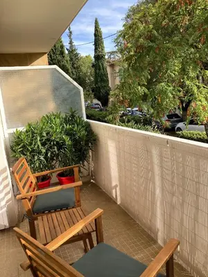 a balcony with two chairs and a bench and a fence at TILIA JOURDAN-Studio Cosy Aix Centre-Cours MIRABEAU-PARKING-WIFI-SMART TV-RUE CALME in Aix-en-Provence