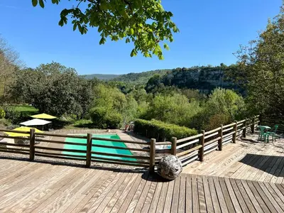 a wooden deck with a fence and a swimming pool at Gîte Nature en Luberon in Céreste