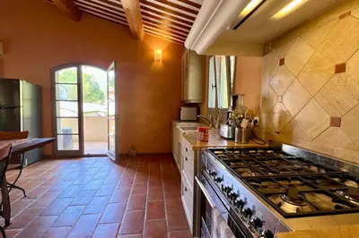 a kitchen with a stove top oven in a room at Maison Marie Provençal Elegance on the Pont Royal Golf Course in Mallemort