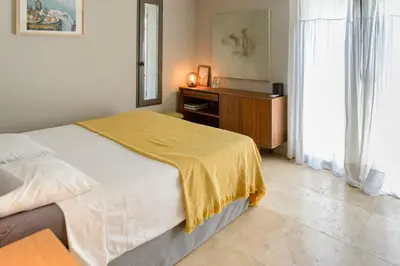 a bedroom with a bed with a yellow blanket on it at Bastide Blanche Villa with swimming pool and pétanque court in Lourmarin in Lourmarin