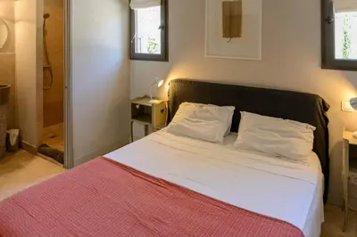 a bedroom with a large bed with a red blanket at Bastide Blanche Villa with swimming pool and pétanque court in Lourmarin in Lourmarin
