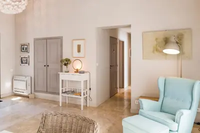 a living room with a blue chair and a table at Bastide Blanche Villa with swimming pool and pétanque court in Lourmarin in Lourmarin