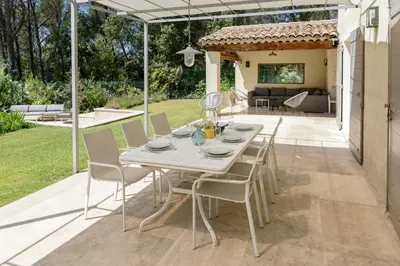 a white table and chairs on a patio at Bastide Blanche Villa with swimming pool and pétanque court in Lourmarin in Lourmarin