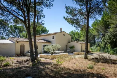 a house with trees in front of it at Bastide Blanche Villa with swimming pool and pétanque court in Lourmarin in Lourmarin