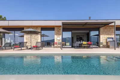 a house with a swimming pool and tables and umbrellas at Villa Mirage luxury and design in Bonnieux in Bonnieux