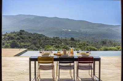 a table with chairs sitting on top of a deck at Villa Mirage luxury and design in Bonnieux in Bonnieux