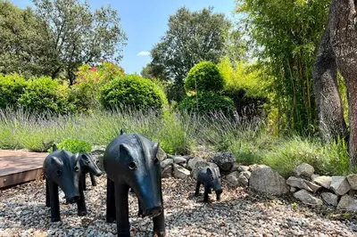 a statue of three elephants in a garden at Villa Maya Large villa and amazing pool in Luberon in Puget