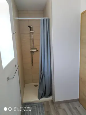a shower with a blue shower curtain in a bathroom at Le Mas des Calus Chambres d'hôtes in LʼIsle-sur-la-Sorgue