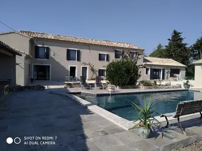 a villa with a swimming pool and a house at Le Mas des Calus Chambres d'hôtes in LʼIsle-sur-la-Sorgue