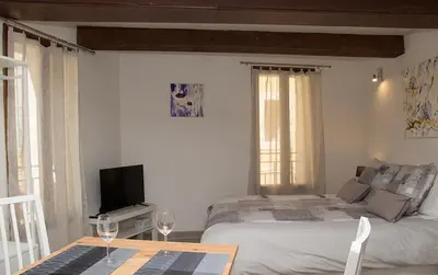 a bedroom with a bed and a table with wine glasses at Gîte les iris in LʼIsle-sur-la-Sorgue