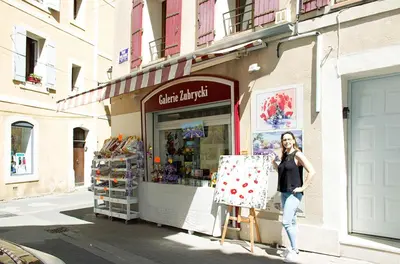 a woman is standing in front of a store at Gîte les iris in LʼIsle-sur-la-Sorgue