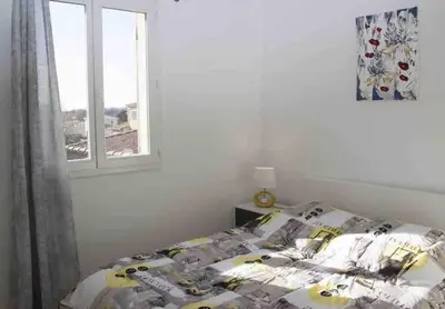 a bedroom with a bed and a window at Gîte les coquelicots 2 Quartier résidentiel ( 2 * ) in LʼIsle-sur-la-Sorgue