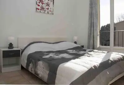 a bedroom with a large bed and a window at Gîte les coquelicots 2 Quartier résidentiel ( 2 * ) in LʼIsle-sur-la-Sorgue