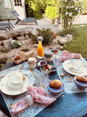 a table with plates of food and a jug of orange juice at B&B Temps Suspendu Provence in Pernes-les-Fontaines