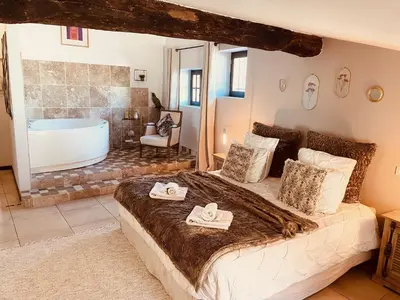 a bedroom with a large bed and a bath tub at B&B Temps Suspendu Provence in Pernes-les-Fontaines