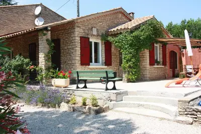 a green bench in front of a brick house at Lou Cigalon in Cabrières-dʼAvignon