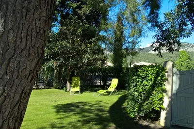 two yellow chairs in a yard next to a fence at Gîte La Charlette in Cheval-Blanc