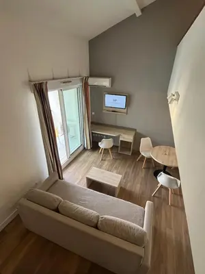 a living room with a couch and a table at Les appartements du Clos de la Chartreuse By Ateya in Aix-en-Provence