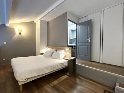a bedroom with a white bed and a window at Les appartements du Clos de la Chartreuse By Ateya in Aix-en-Provence