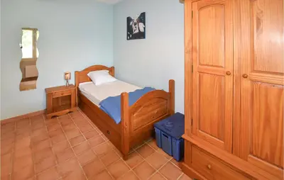 a small bedroom with a bed and a wooden cabinet at Amazing Home In Mazan With Kitchen in Mazan