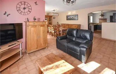 a living room with a black leather couch and a tv at Amazing Home In Mazan With Kitchen in Mazan