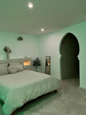a bedroom with a large bed and an arched doorway at La Suite du clocher in Noves