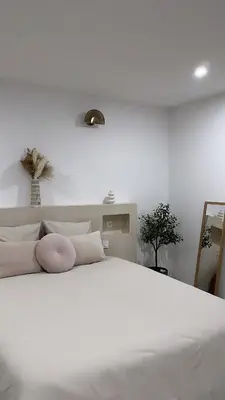 a white bedroom with a large white bed with pillows at La Suite du clocher in Noves