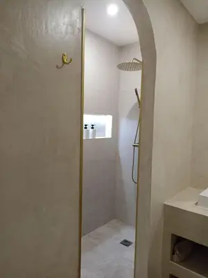 a shower with a glass door in a bathroom at La Suite du clocher in Noves