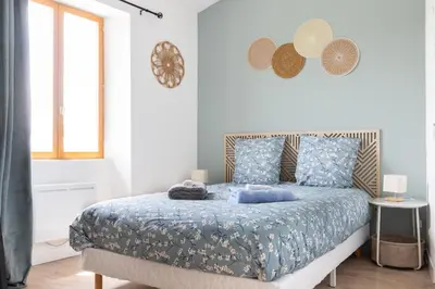 a bedroom with a bed with blue sheets and a window at L'Isle en Blanc - 4 couchages - Hypercentre - Clim - Wifi in LʼIsle-sur-la-Sorgue