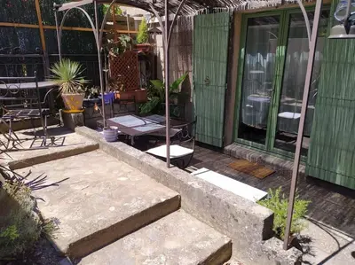 a patio with stairs and a building with plants at Au petit Florian en Provence in Apt