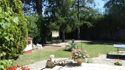 a garden with a table and flowers in the grass at Mas Grimaud - Gîte- Studio et chambres d'hôtes familiales in Eygalières