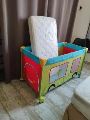 a toy train crib with a white mattress at Charmante Maison au pied du Luberon in Cheval-Blanc