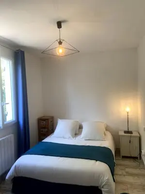 a bedroom with a large bed with a blue blanket at Charmante Maison au pied du Luberon in Cheval-Blanc