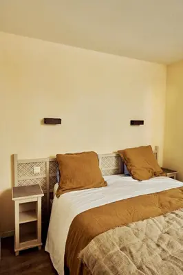 a bedroom with a bed and a side table at Bastidon Golf de Pont Royal in Mallemort