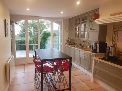 a kitchen with a table and some stools in it at Charmante villa 4 chambres, piscine et superbe vue in Éguilles
