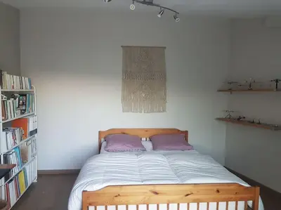 a bedroom with a wooden bed with purple pillows at Charmante villa 4 chambres, piscine et superbe vue in Éguilles