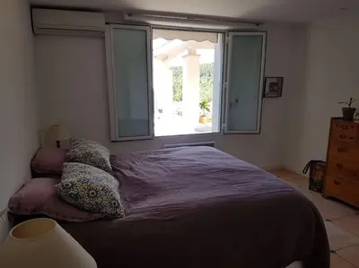 a bedroom with a large bed with a window at Charmante villa 4 chambres, piscine et superbe vue in Éguilles