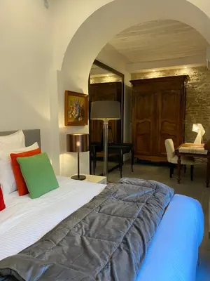 a bedroom with a large bed and a desk at La RENAUDIERE in LʼIsle-sur-la-Sorgue