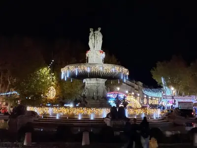 a large fountain with christmas lights at night at Aix en Provence - Rotonde - Cours Mirabeau in Aix-en-Provence