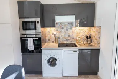 a kitchen with a washing machine and a sink at El Sama-In , Piscine chauffée in LʼIsle-sur-la-Sorgue