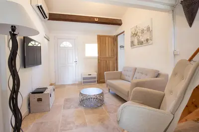 a living room with a couch and a table at El Sama-In , Piscine chauffée in LʼIsle-sur-la-Sorgue