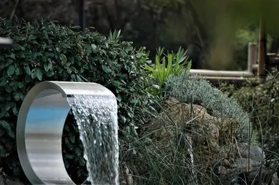 a water fountain in front of a bush at Coin de paradis en Provence in Saint-Cannat