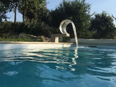 a swimming pool with a water fountain at Coin de paradis en Provence in Saint-Cannat