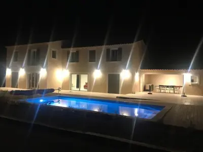a swimming pool in front of a house at night at Imola - Côté Ventoux in Bédoin