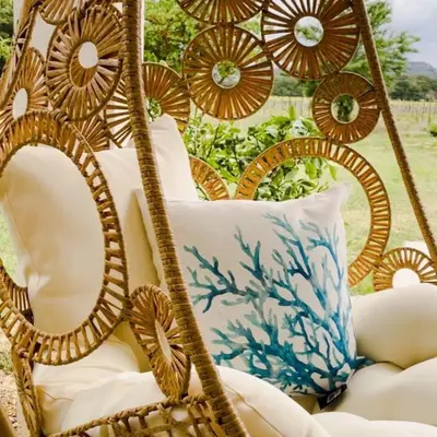a wicker chair with a pillow in a yard at Villa avec Pool House au cœur des vignes - Lubéron in La Tour-dʼAigues