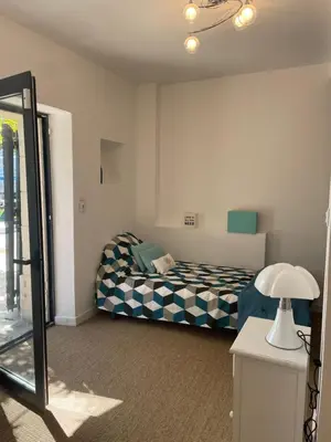 a bedroom with a bed and a lamp and a mirror at Villa avec Pool House au cœur des vignes - Lubéron in La Tour-dʼAigues